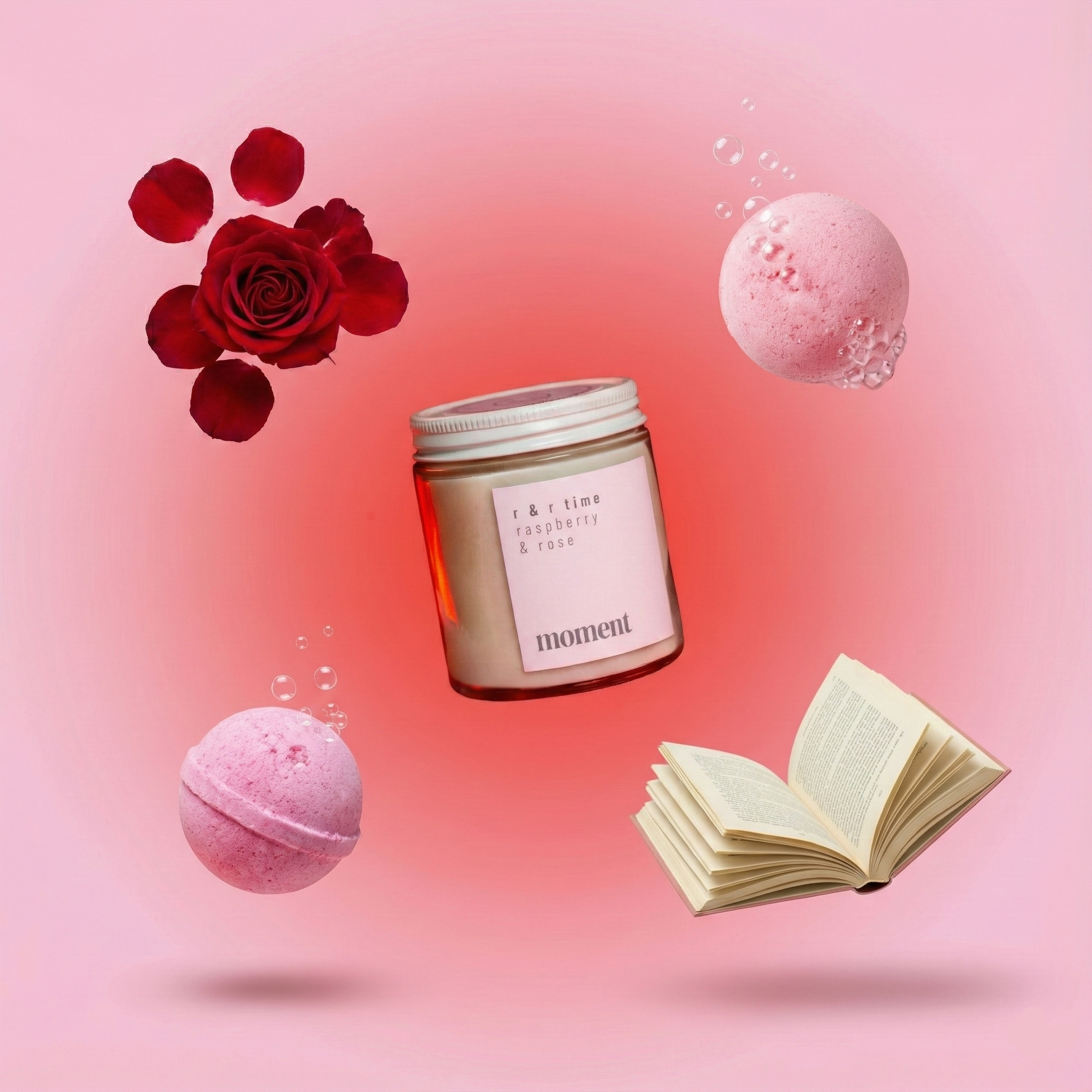 Candle, bath bombs, and an open book on a pink background with a rose.